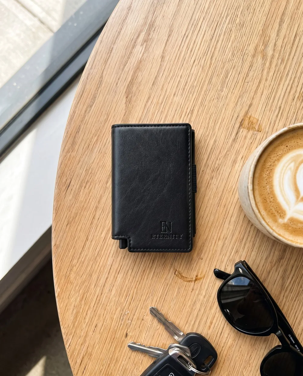 Luzof on a café table with a flat white, keys and sunglasses