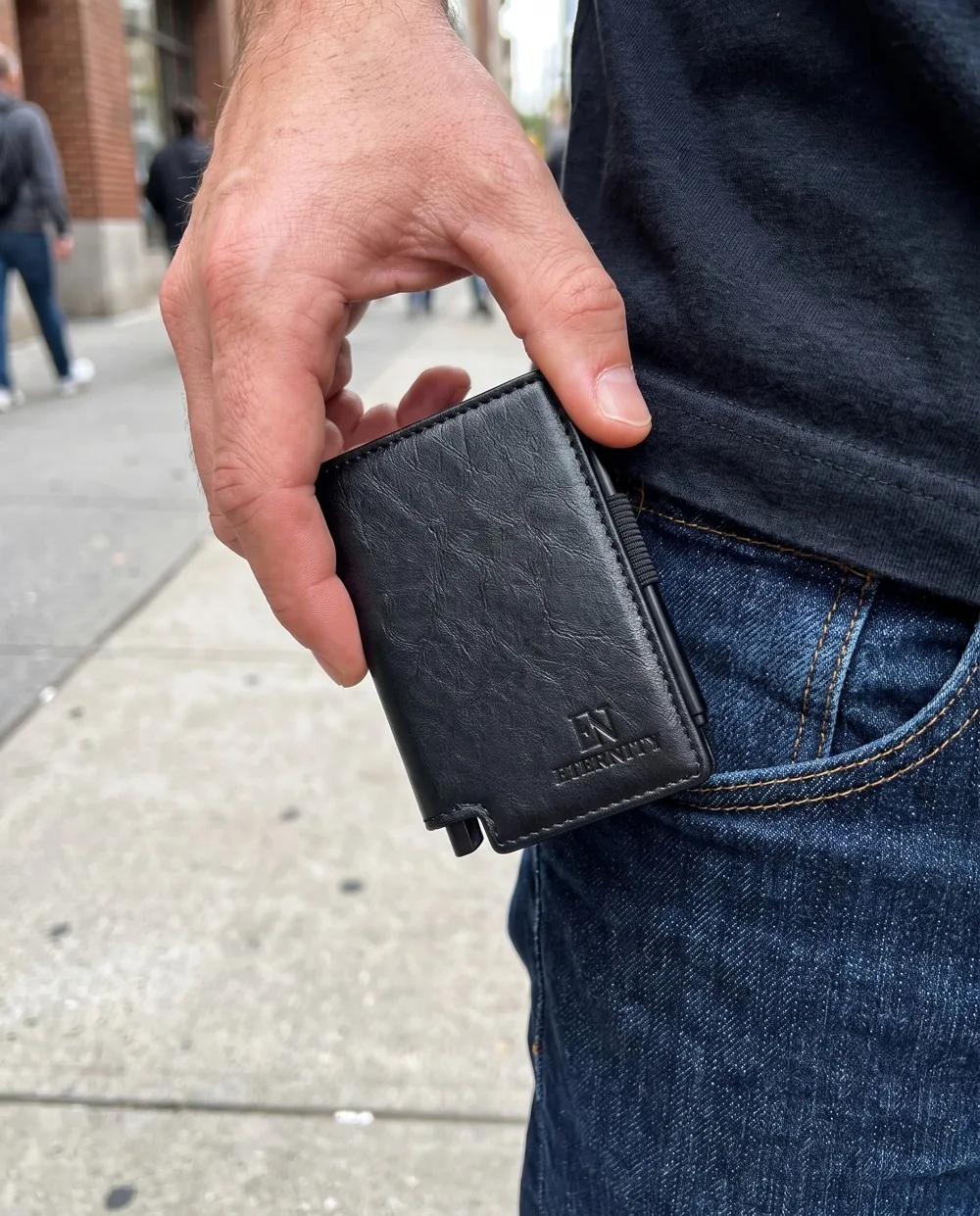 Luzof being pulled from a jeans pocket on a city street